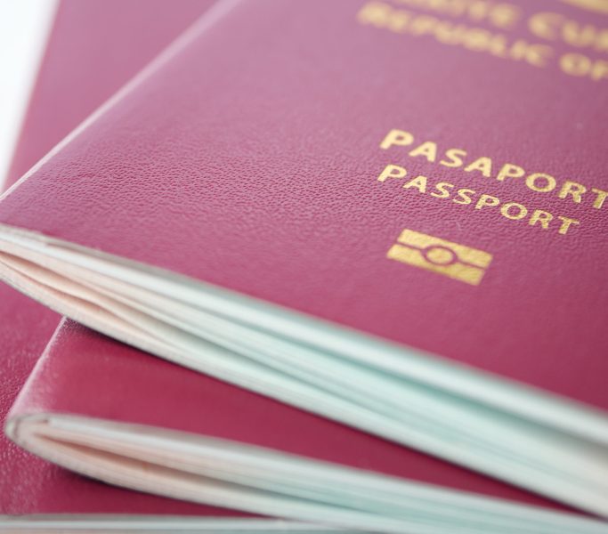 stack of red color passport on table .